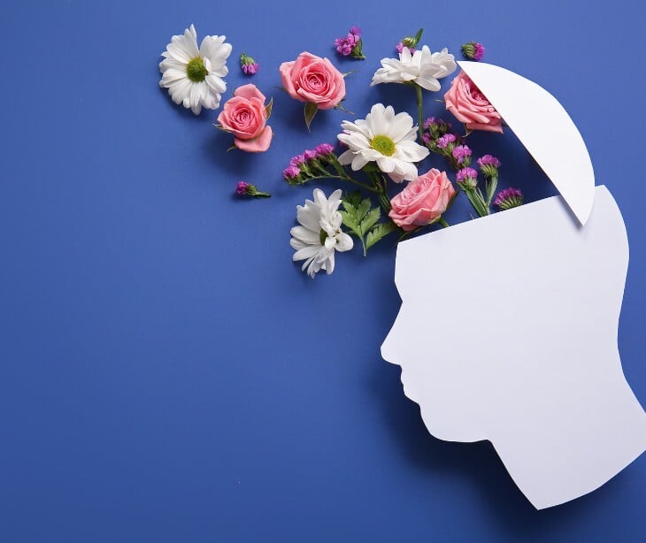 Image of a paper head cut out, with flowers coming out.