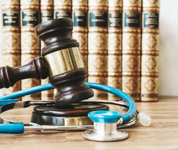 law gavel in front of books with a stethescope