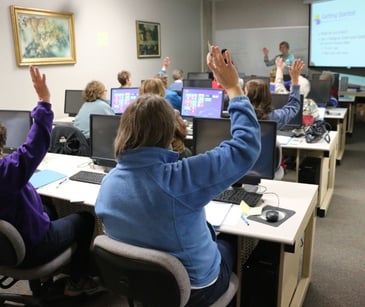 employees in a training room with computers and instructor