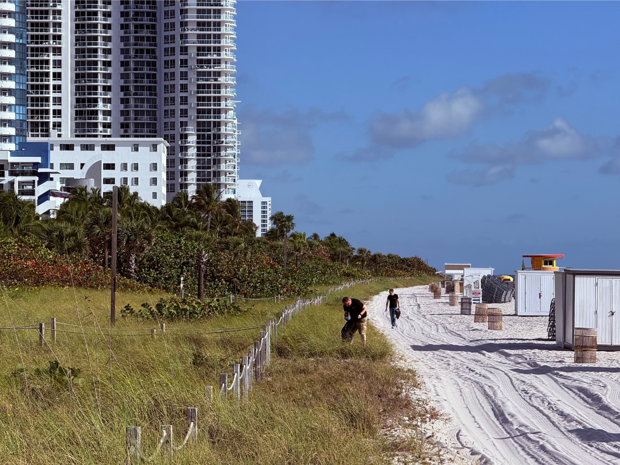 Scenic action shot of Robert Ogus and Don Beesing scanning Miami Beach for litter.