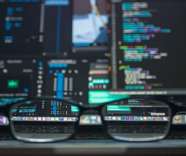 glasses in front of a computer screen