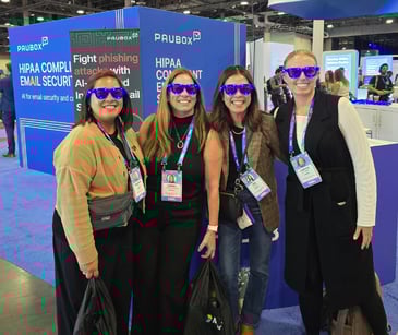 HTLTH 2025 attendees at the Paubox booth with our flashing sunglasses