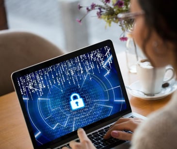 woman on laptop with security icon on screen