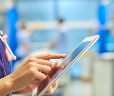 nurse in healthcare setting holding tablet
