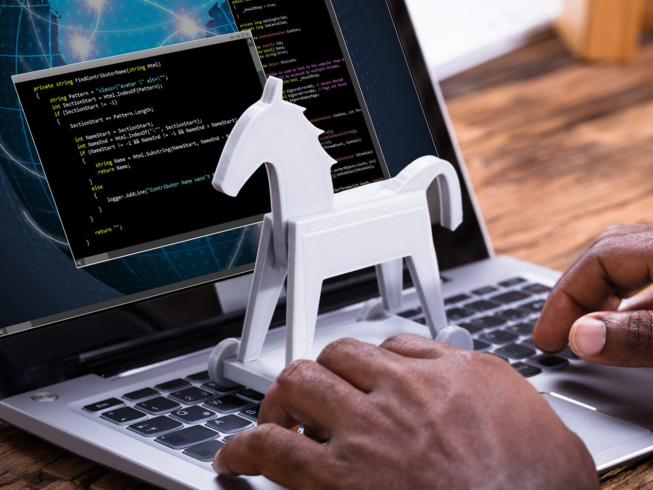 man on laptop with trojan horse virus