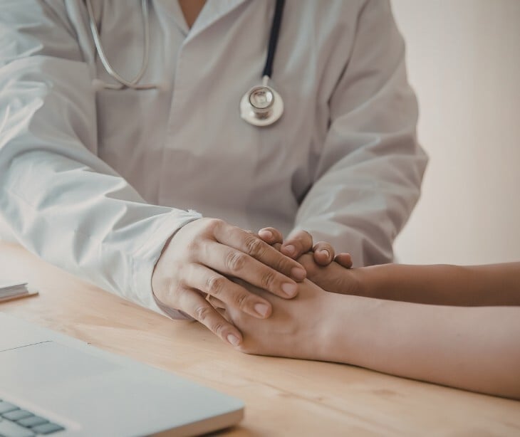 Image of a provider touching the hands of a patient. 