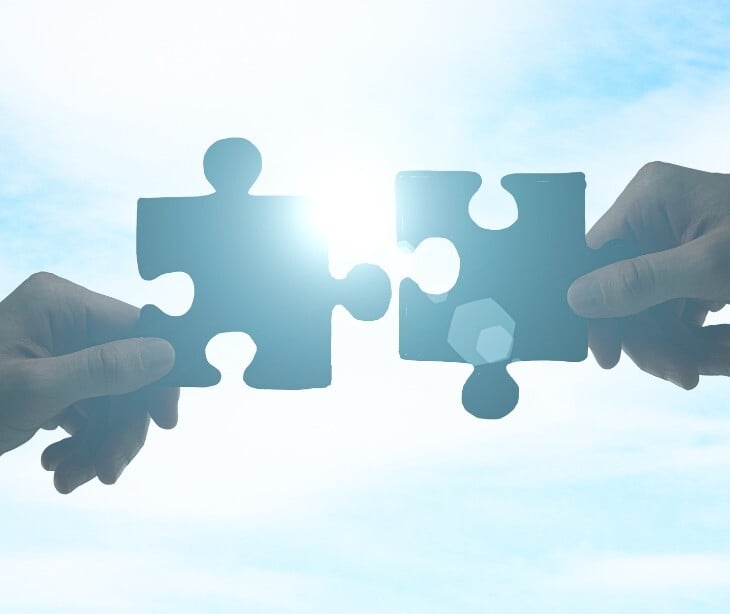 Image of two puzzle pieces coming together. 