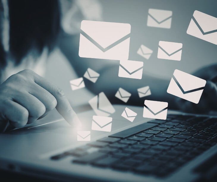 Image of someone a laptop with email icons coming out of it. 