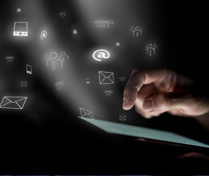 hand over tablet with floating email icons