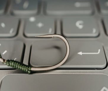 Image of a fishing hook on a keyboard. 