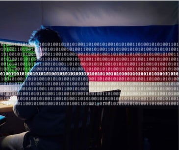 hacker at computer in front of russian flag