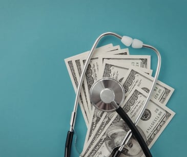 Image of a stethascope wrapped in money. 