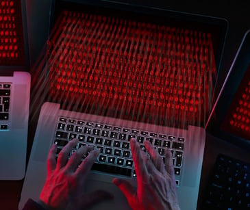 hands at a laptop computer with red screen