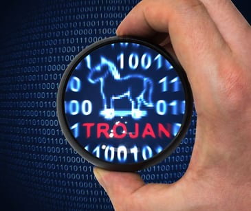 magnifying glass over computer code that says trojan