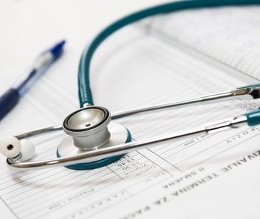 stethoscope and pen on paperwork