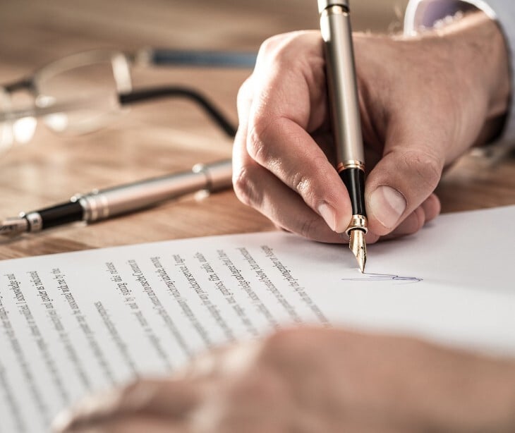 Image of someone signing a contract. 