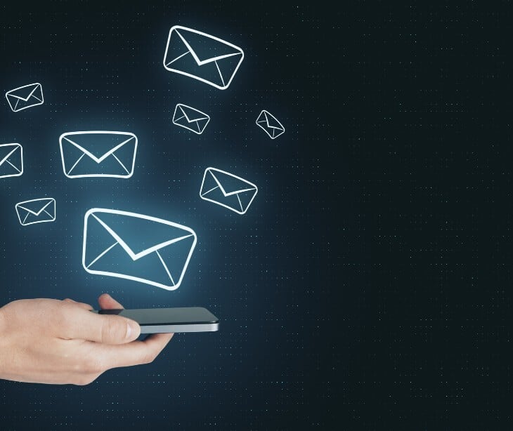 Image of an email icon coming out of a phone. 