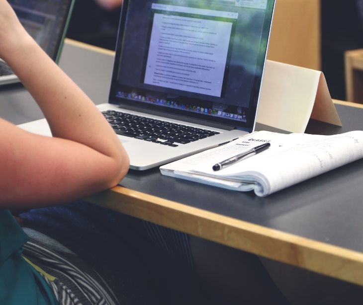 Image of someone taking notes on a laptop.