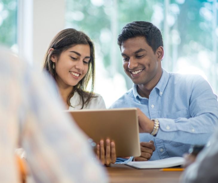 man and woman looking at tablet