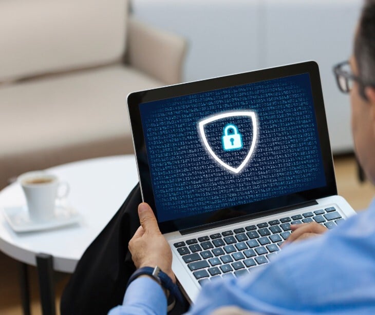 Image of someone on a computer with a shield on it. 