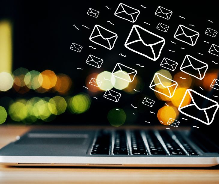 email icons floating over a laptop computer