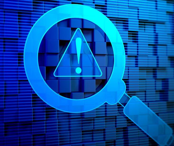 magnifying glass on caution symbol