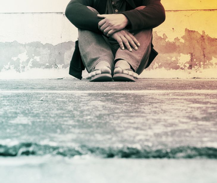 person sitting on sidewalk