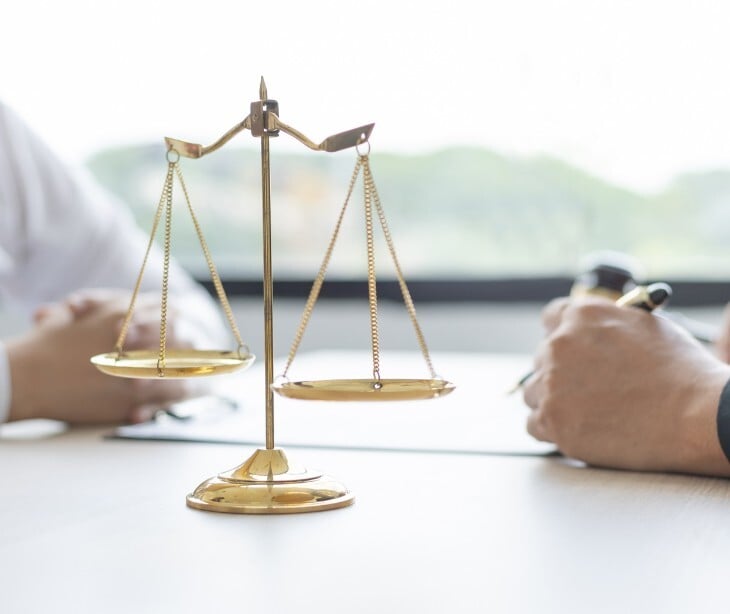 Image of a scale and two people at a table. 
