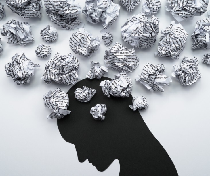 Image of a drawing with someone who has crumbled paper coming out of their head.