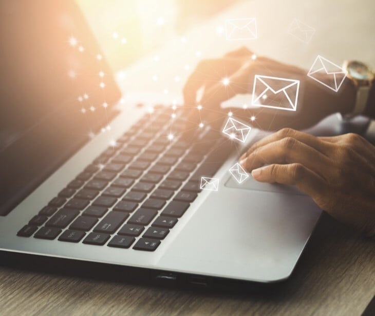 email icons floating over laptop