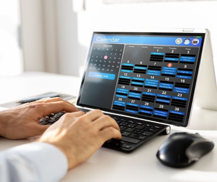 Image of someone looking at a schedule on their computer. 