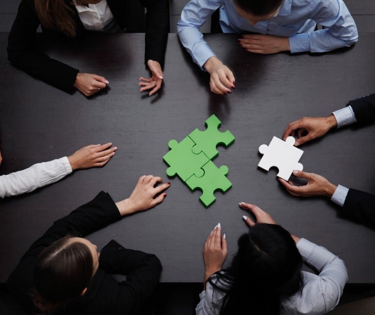 Image of a group with large puzzle pieces. 