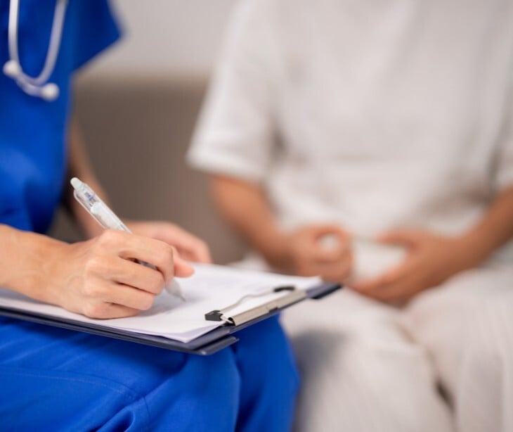Image of a practicioner taking notes with a patient. 