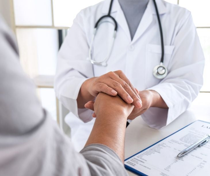 Image of a provider holding a patients hand. 