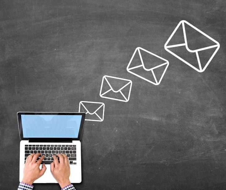Image of emails coming out of a computer. 