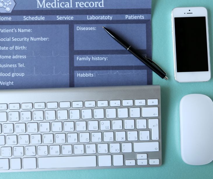 laptop keyboard with health record paperwork