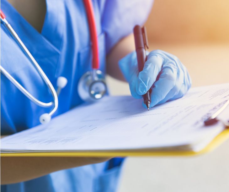 provider writing on a clipboard of paperwork