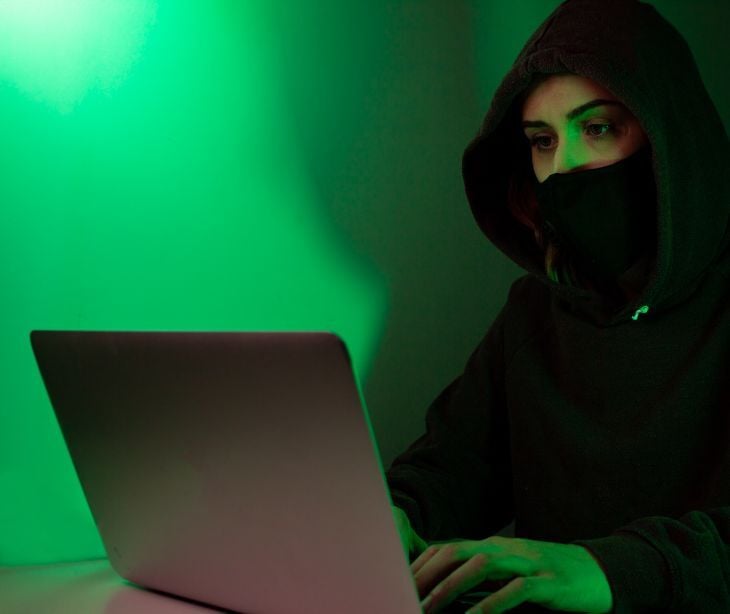 Image of a masked figure on a computer. 