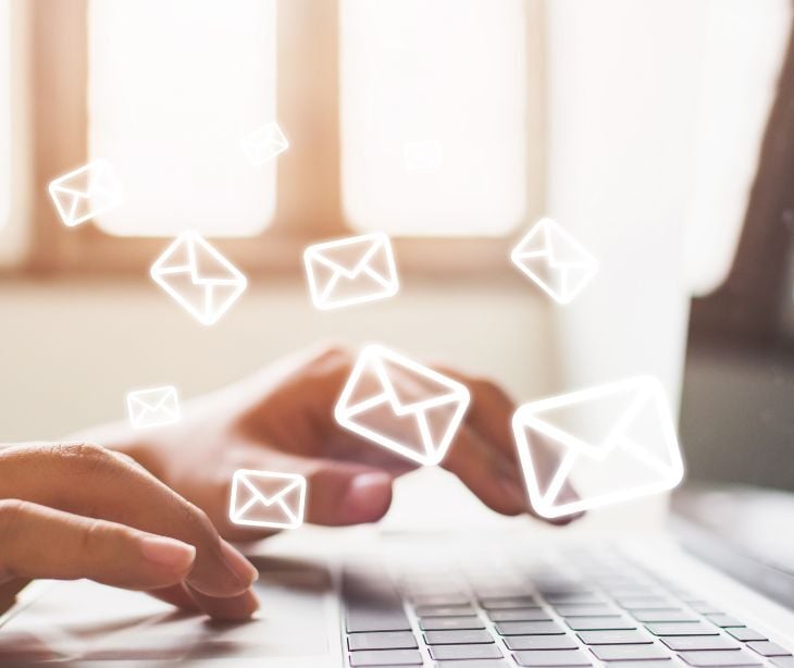 Image of email icons coming out of a laptop. 