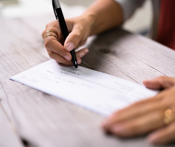 Image of someone writing a check. 