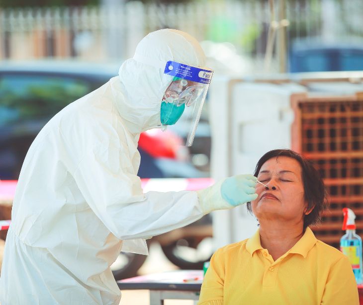 public health employee giving a vaccine through the nose