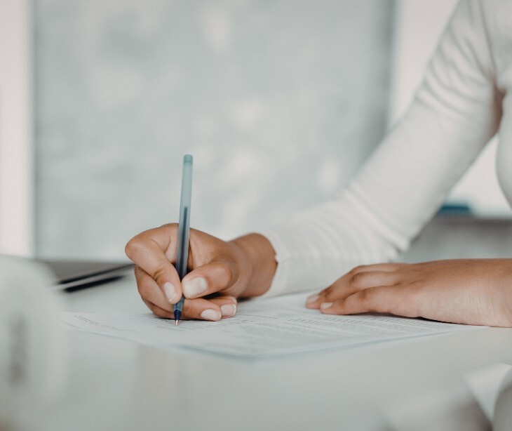 Image of an individual signing a document. 