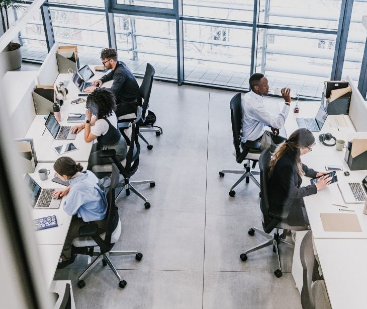 Image of people on computer desks. 