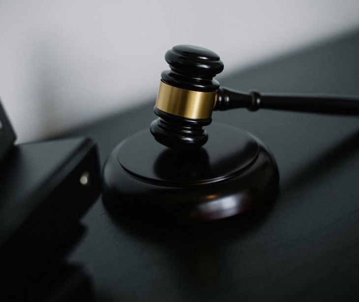 Image of a gavel next to a binder. 