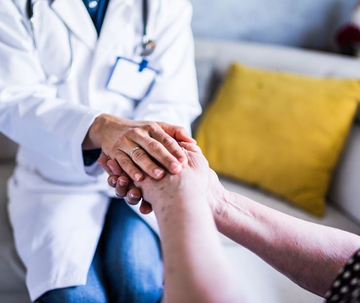 healthcare provider holding the hands of a patient
