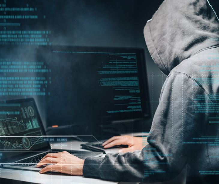 hacker in a hooded sweatshirt using a computer
