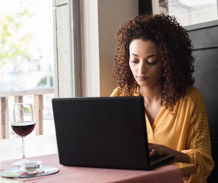 woman on laptop at a bar