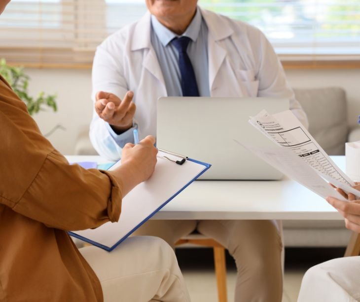 Image of a doctor talking to two individuals. 
