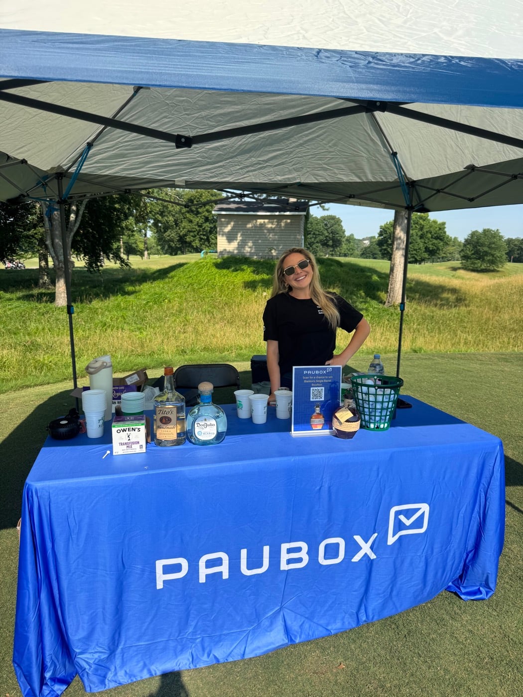 Paubox team member at the table with a QR giveaway sign.