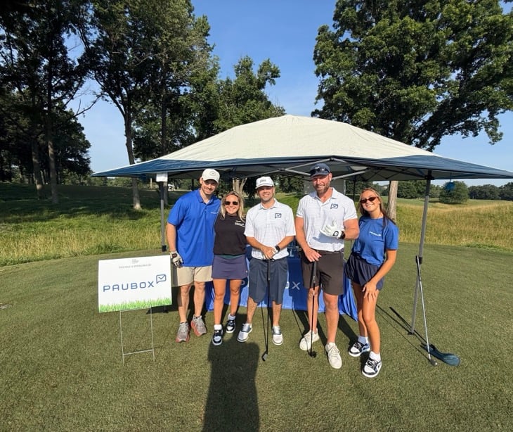 Five Paubox team members under a tent at the HIMSS Tennessee Chapter Golf Outing beside a "This hole is sponsored by Paubox" sign.